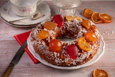 Cake of the kings, brioche with candied fruits for the Epiphany on a wooden table
