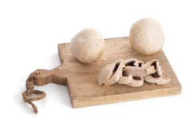 Beyaz arkaplanda kesme tahtasında beyaz mantar (Agaricus Bisporus)