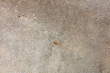 Arka planda çatlak olan gri beton bir madde.