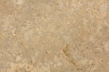 Arka planda çatlak olan gri beton bir madde.