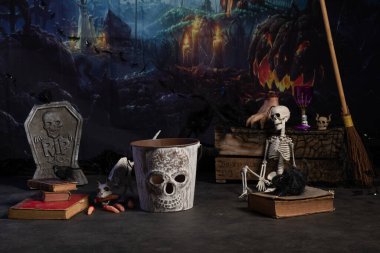 Dark Halloween decor with a grave, fingers and grimoires