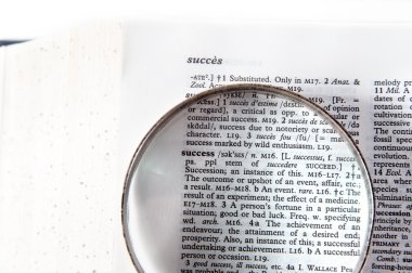 A magnifying glass on the word success clipart