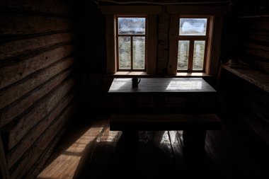 Ahşap bir evin iki penceresi olan kütük bir oda, köy, temiz bir gün, ahşap çerçeveler, ahşap masa ve sandalyeler, güzel ahşap iç mekan..