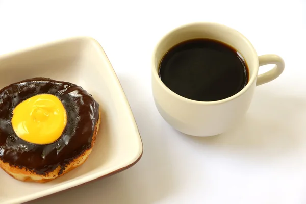 Шоколадный пончик с чашкой кофе — стоковое фото