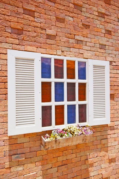 Fenêtre blanche avec pots de fleurs sur le mur de briques . — Photo