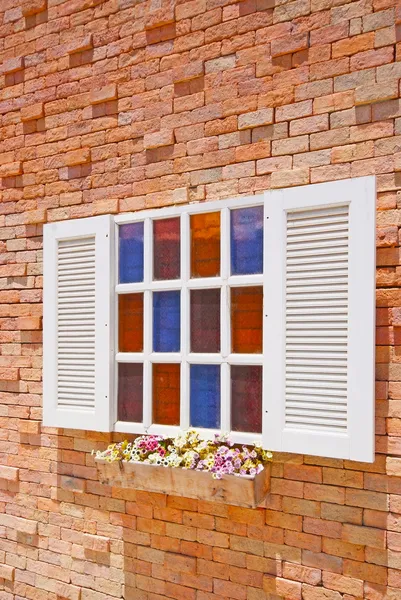 Weißes Fenster mit Blumentöpfen an der Ziegelwand. — Stockfoto