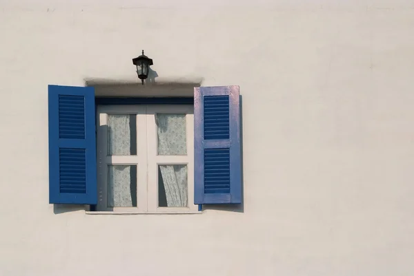 Blaue Fenster an der Wand — Stockfoto