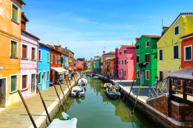 BURANO ISLAND, VENICE, ITALY - JULY 4, 2022: Tourists and Colorful houses on the canal in Burano island, Venice, Italy. Famous travel destination. 