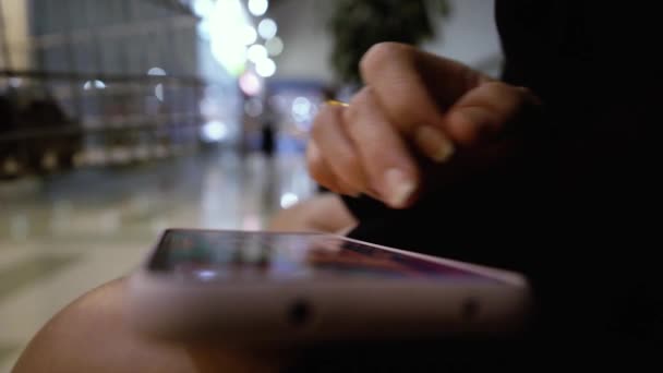 Close up of female hands playing video game on smartphone in the mall — Stockvideo
