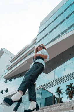 Non-binary executive young of LGBTQ community walking on stairs front of a building