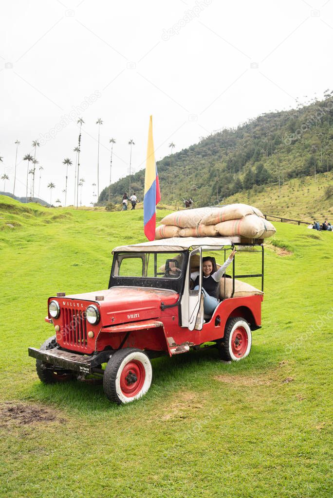 Young latin woman in Jeep Willys in the Cocora Valley, Salento, Colombia, South America