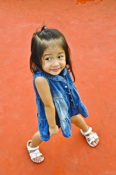 Little Asian girl in blue jeans. — Stock Photo, Image