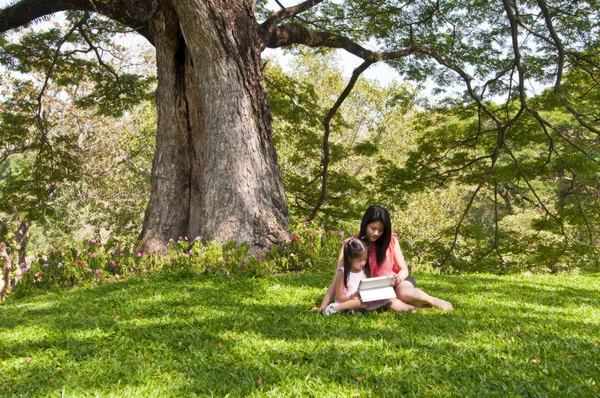 küçük Asyalı kız ve anne tablet pc Park zevk.