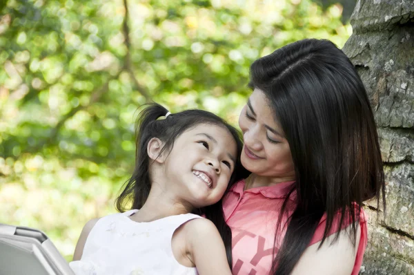 küçük Asyalı kız ve anne tablet pc Park zevk.