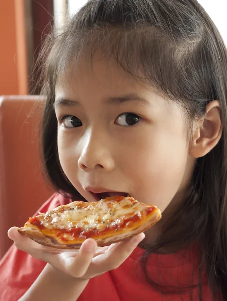 küçük Asyalı kız zevk pizza yemek.