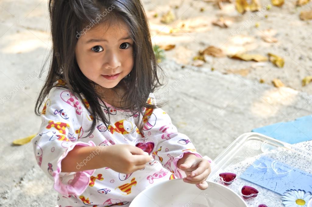 Little Asian girl making jelly.