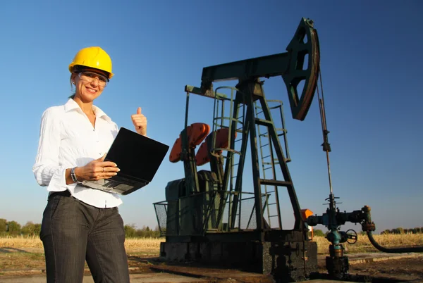 Femme ingénieure souriante dans un champ pétrolifère — Photo