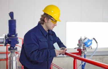 Worker controls devices in a power plant clipart