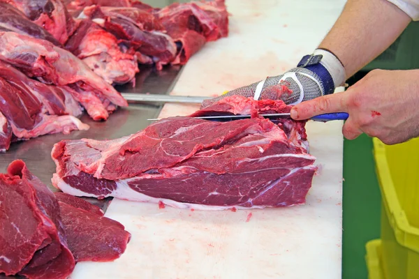 Butcher cutting a fresh beef meat — Stock Photo, Image
