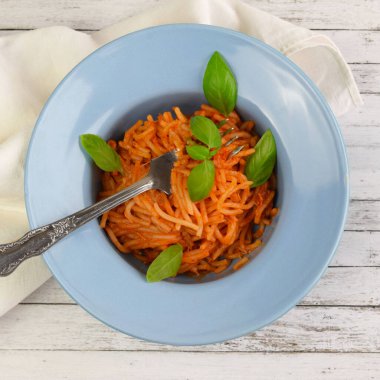Lezzetli İtalyan spagettisi domates sosu ve taze fesleğen, akşam yemeği için sağlıklı pişirilmiş makarna ve bir gurme restoranında öğle yemeği..