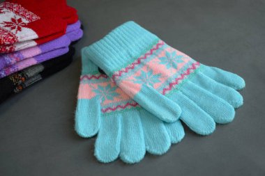 Gri bir arka planda çok renkli örgü eldivenler..