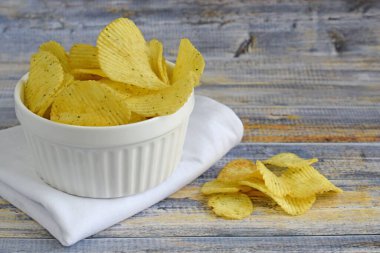 Ekşi kremalı çıtır patates cipsi ve ahşap arka planda soğan..