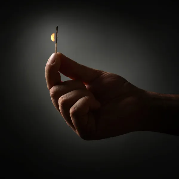 Hand holding burning match — Stock Photo, Image