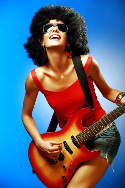 Sensual woman playing on the electric guitar