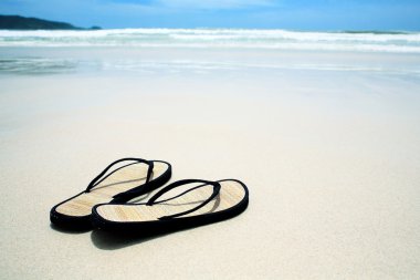 Flip flops on the sand on paradise beach clipart