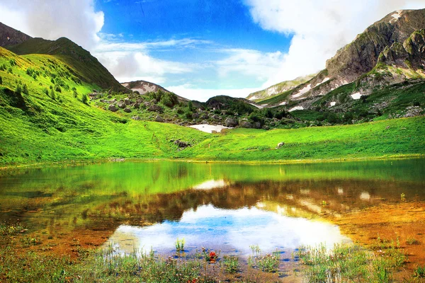 Maravilloso paisaje con lago de montaña, prado alpino y montañas — Foto de Stock