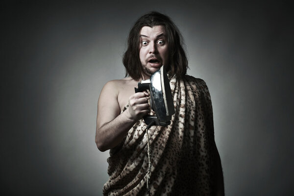 Дикарь в леопардовой шкуре держит старое железо
.