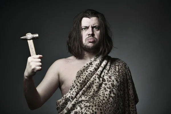 Wild man wearing leopard skin hold old hammer. — Stock Photo, Image