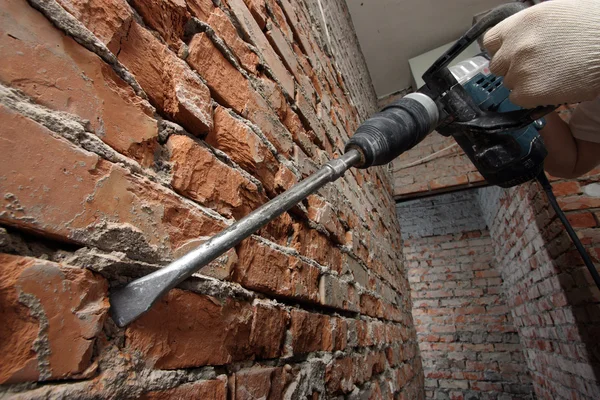 Mannens händer anläggning plugger mot tegelväggen — Stockfoto