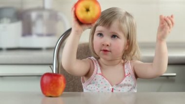 Kırmızı elma ile oynayan bebek