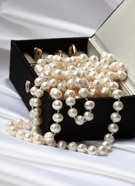 Pearls and rings in black jewelry box — Stock Photo, Image