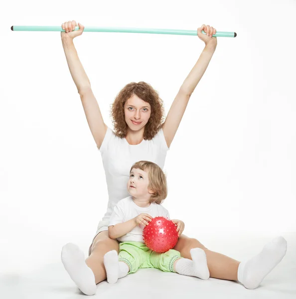 Счастливая мама делает спортивные упражнения с маленькой дочерью — стоковое фото