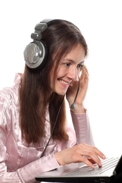 Jovem sorridente atraente com fones de ouvido e laptop — Fotografia de Stock