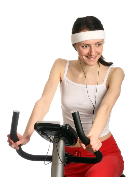 Glückliche junge Frau auf einem Trainingsfahrrad — Stockfoto