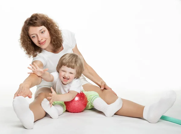 Szczęśliwa matka robi ćwiczenia sportowe z małą córeczkę — Zdjęcie stockowe