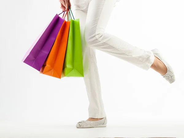 Ragazza in possesso di sacchetti di carta multicolore shopping primo piano colpo su sfondo bianco — Foto Stock