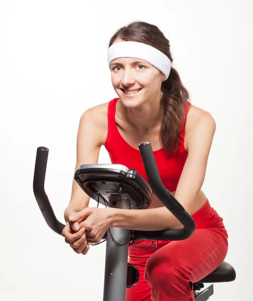 Mujer joven en una bicicleta de entrenamiento — Foto de Stock