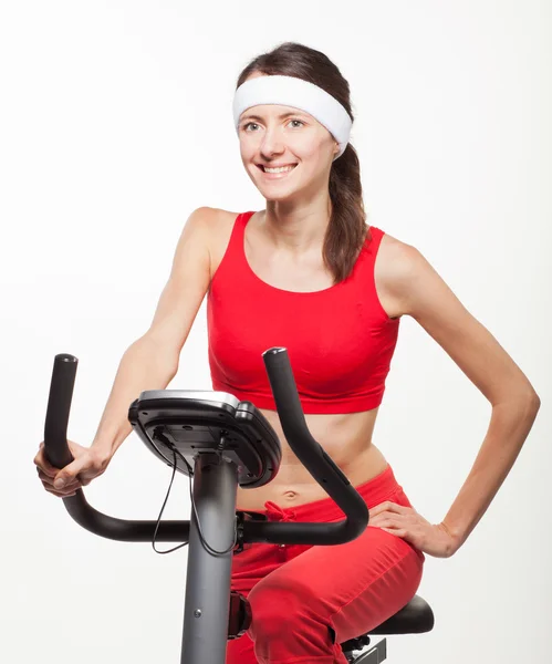 Junge Frau auf einem Trainingsfahrrad — Stockfoto