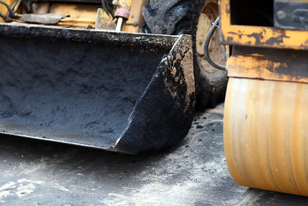 Närbild av frontala lastare skopa och road roller — Stockfoto