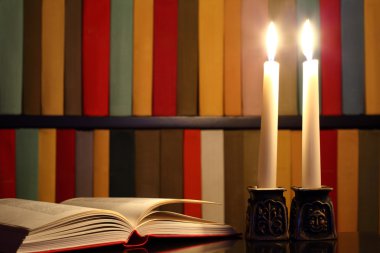 kitap, mumlar ve kitap rafı arka planda açılan