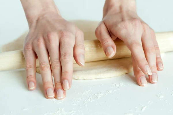 Händer rulla ut degen i mjöl — Stockfoto
