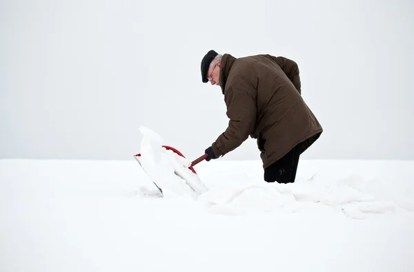 Человек убирает снег лопатой — стоковое фото