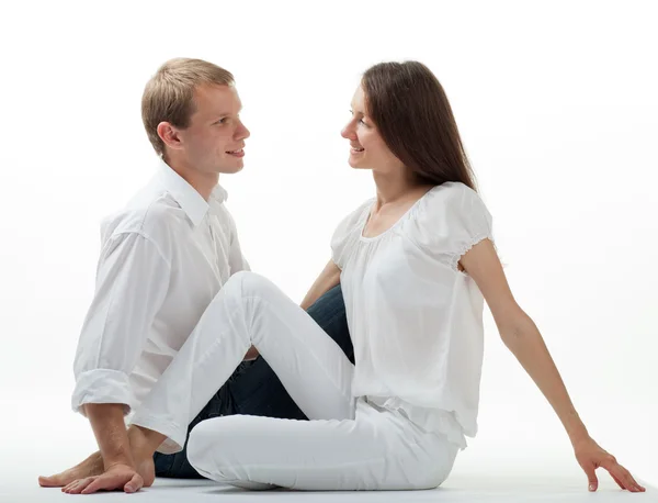 Jonge glimlachend flirten paar zittend op de vloer — Stockfoto