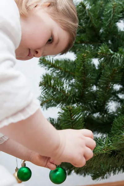 Klein meisje versieren van een kerstboom — Stockfoto