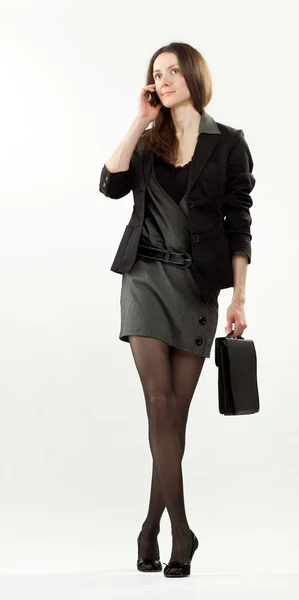 Giovane donna d'affari che cammina e parla al cellulare — Foto Stock