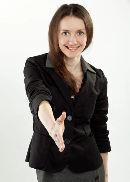 Jovem mulher de negócios sorrindo estendendo a mão para aperto de mão — Fotografia de Stock